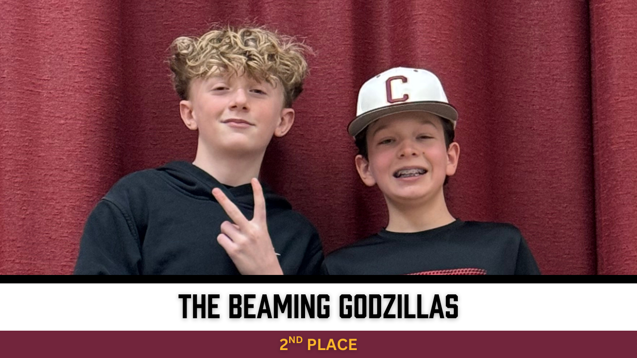 Two students stand in front of red curtain, smiling